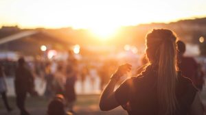 Person enjoying sunset at a vibrant outdoor event.