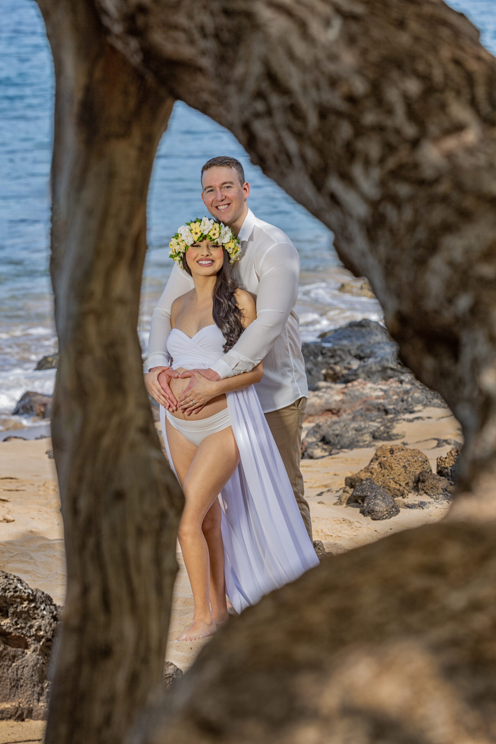 Couple poses together on a beach.