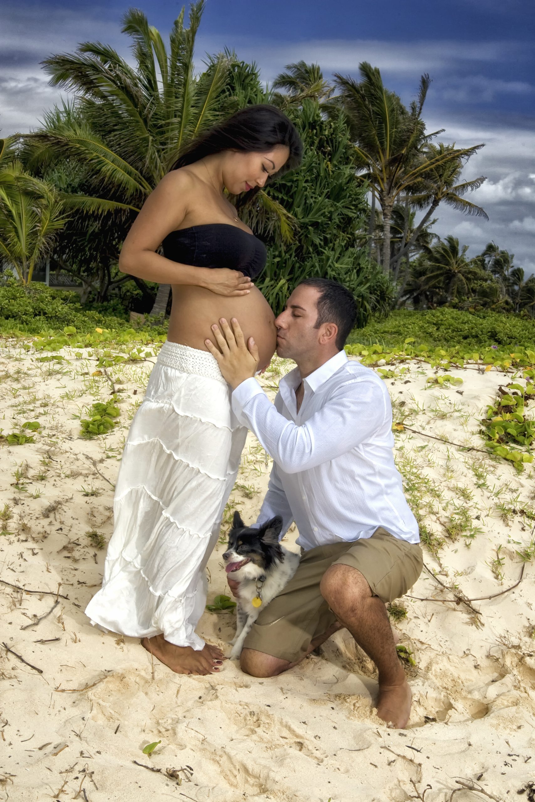 Couple celebrating pregnancy on a beach.