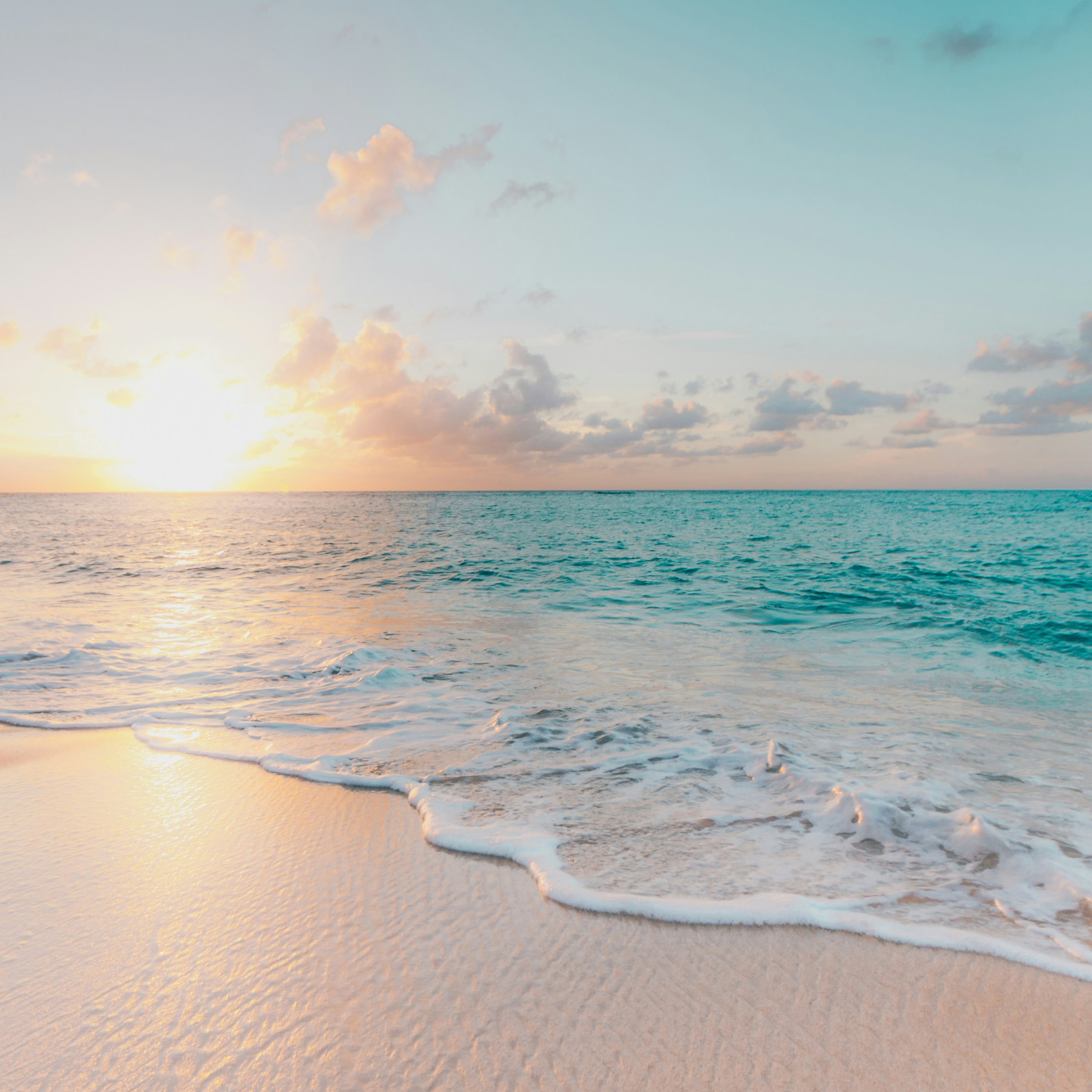 Sunset over calm ocean waves at the beach