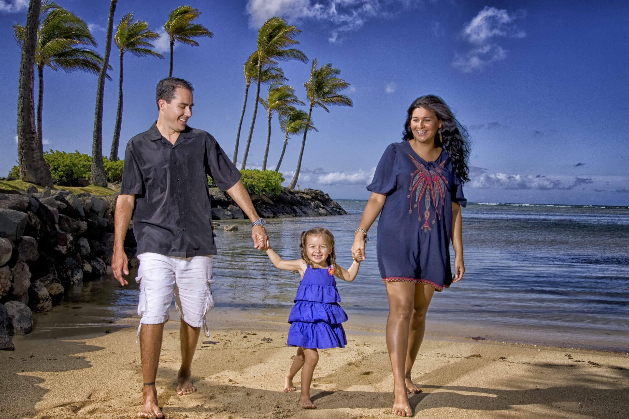 Family walking hand in hand on the beach.