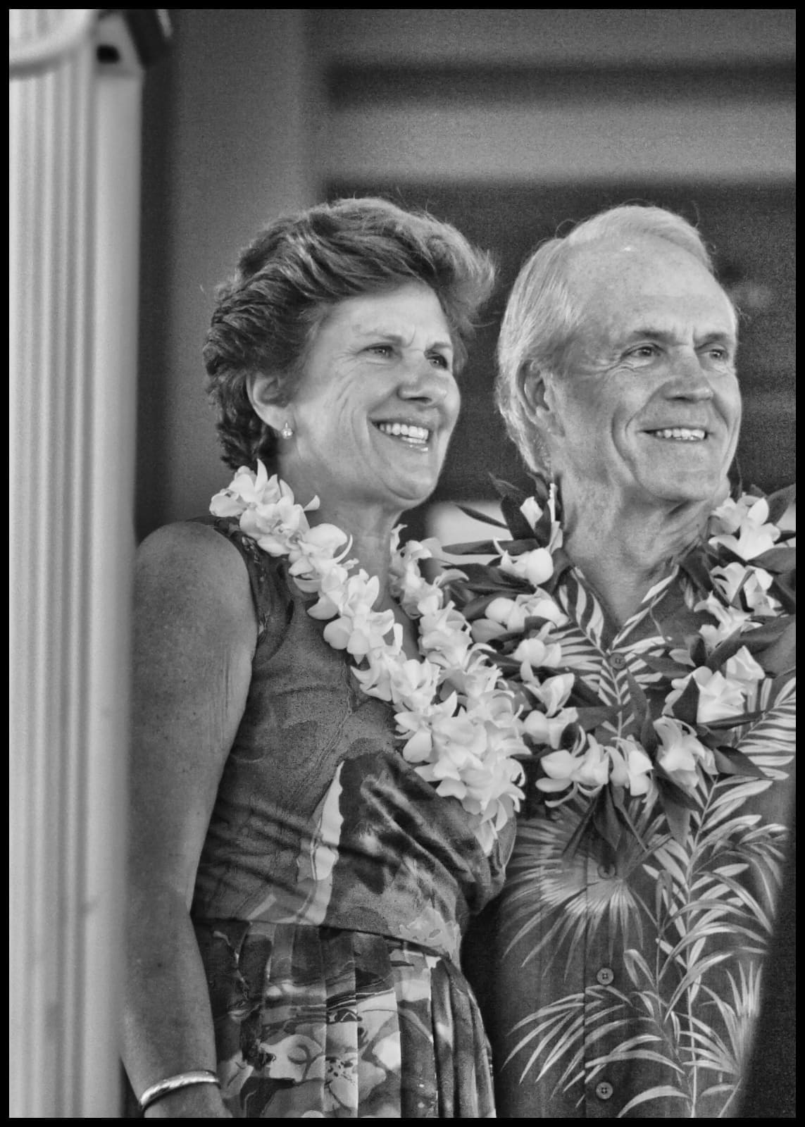 Couple smiling in tropical attire with leis