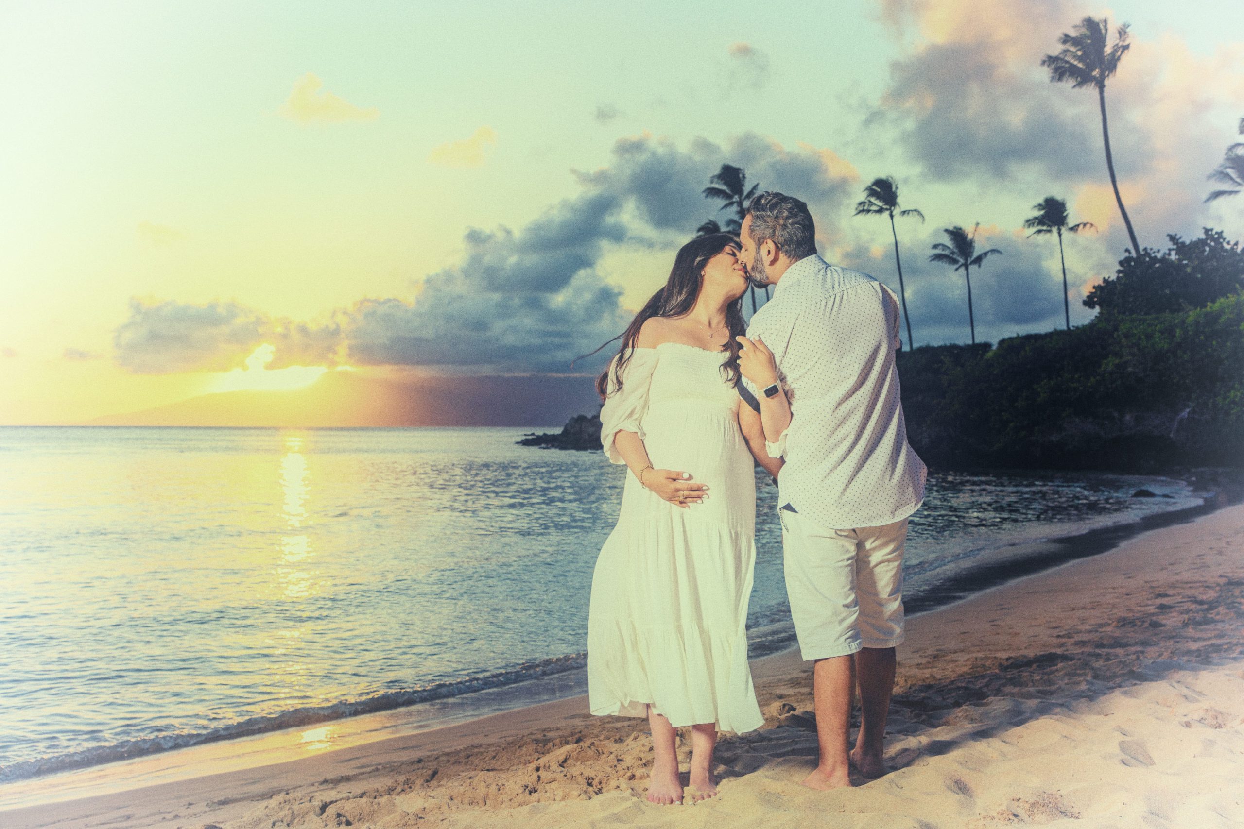 Couple kissing during a sunset on the beach.