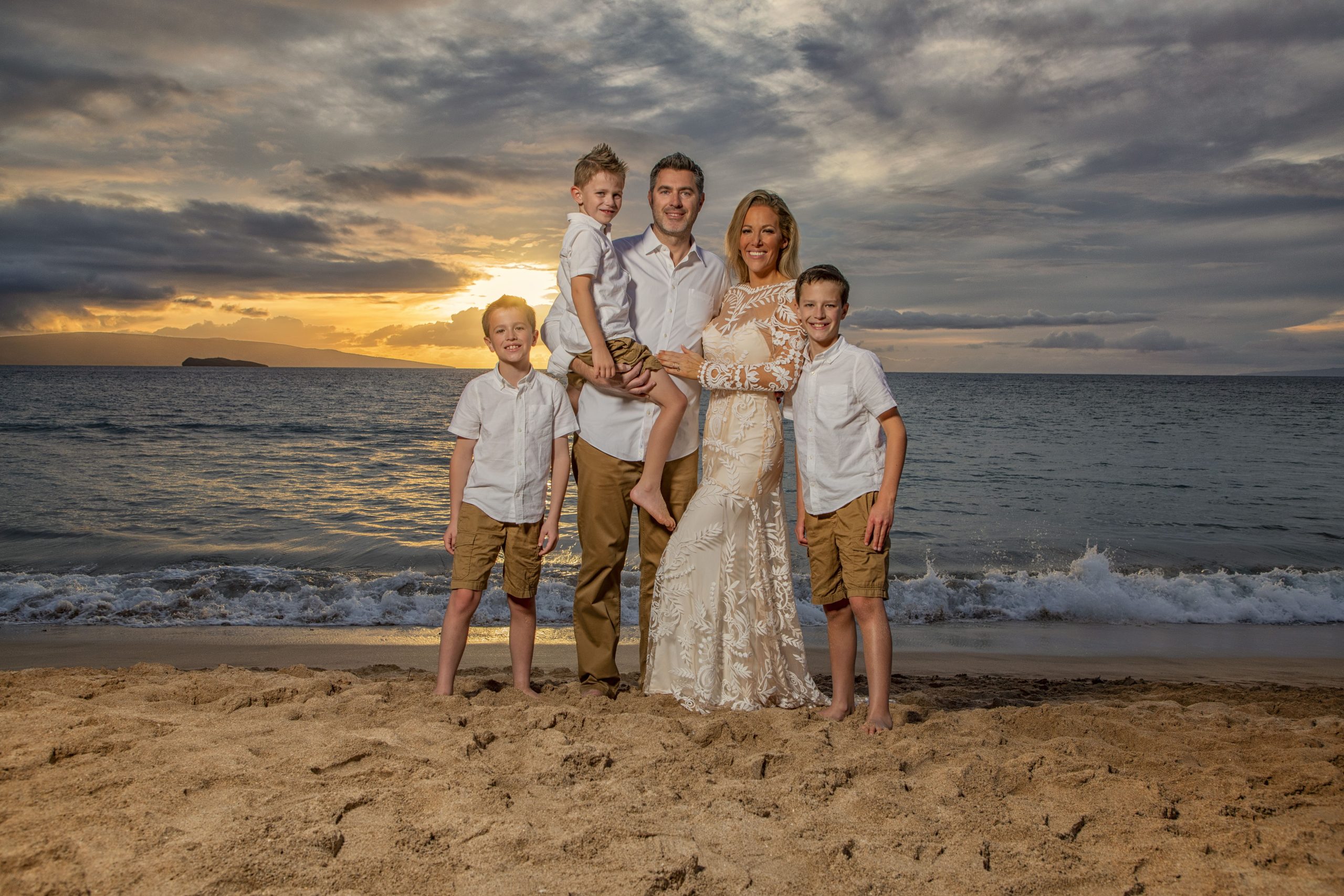 Family portrait on the beach at sunset.