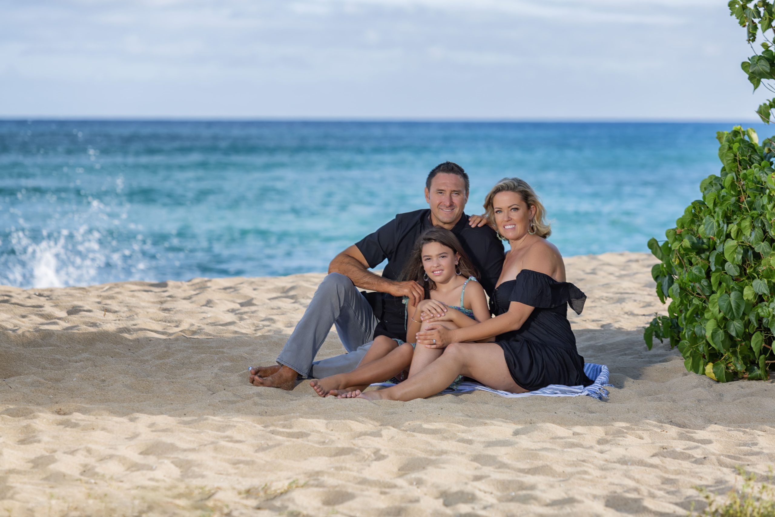 Family sitting together on the beach.