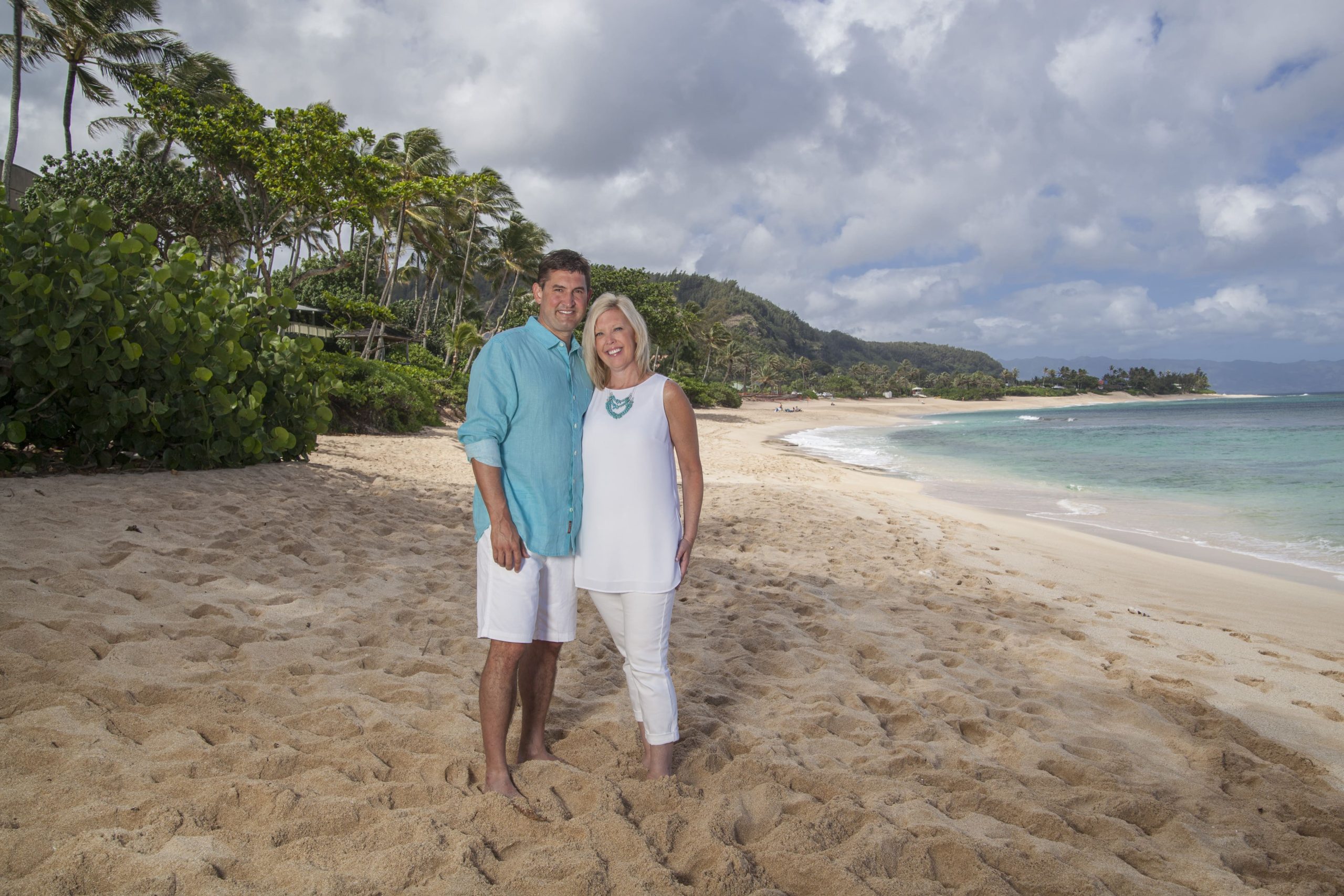 Couple posing on a picturesque sandy beach.